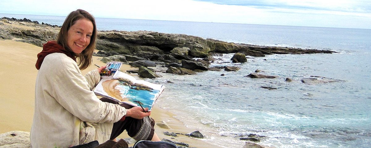 kellie day painting in her art journal on the beach in mexico