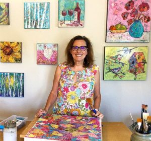 Ruth Austin with all her paintings from kellie day art mentoring program