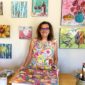 Ruth Austin with all her paintings from kellie day art mentoring program